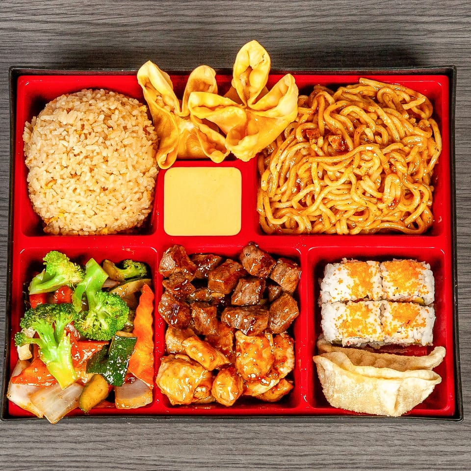 A bento box filled with fried rice, lo mein, crab rangoons, mixed vegetables, beef, chicken, sushi, and a dumpling.
