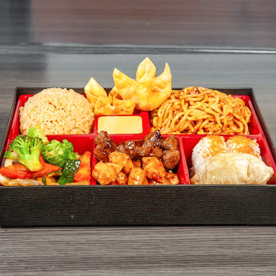 A bento box filled with fried rice, lo mein, crab rangoons, mixed vegetables, beef, and sushi.